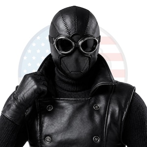 May include: A black full-head mask with visible stitched seams and integrated dark-tinted goggles featuring silver-toned rims. The mask is paired with a black double-breasted jacket with buttons and matching black leather gloves over a dark sweater.