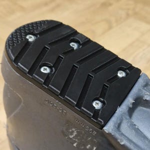 May include: Close-up of a black ski boot sole with a textured tread pattern. The sole is attached with silver screws. The boot size is 26-26.5, and the sole length is 295 mm.