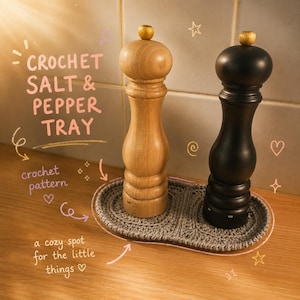 Op de afbeelding: Een licht houten zoutmolen en een zwarte pepermolen op een ovaal grijs gehaakt dienblad. De afbeelding bevat de tekst: CROCHET SALT & PEPPER TRAY, crochet pattern, en a cozy spot for the little things, samen met enkele getekende sterren.
