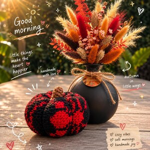 Op de afbeelding: Een zwarte ronde vaas met een droogbloemenarrangement in rood-, oranje- en bruintinten, gecombineerd met een gehaakte pompoen in een rood en zwart ruitpatroon. De afbeelding bevat de tekst: Good morning, little things make the heart happier, handmade with love, autumn in little ways, cozy vibes, soft mornings, handmade joy.