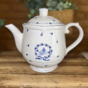 Tetera de cerámica blanca con decoración azul transferida.