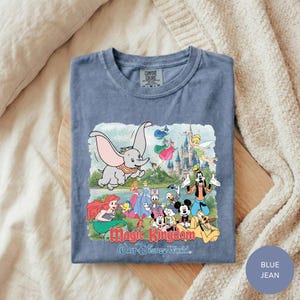 A t-shirt with a colorful graphic design featuring various Disney characters and a castle, along with the text "Magic Kingdom Walt Disney World."