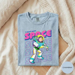 A gray t-shirt with a colorful graphic of a character from the Toy Story franchise, specifically Buzz Lightyear, printed on it.