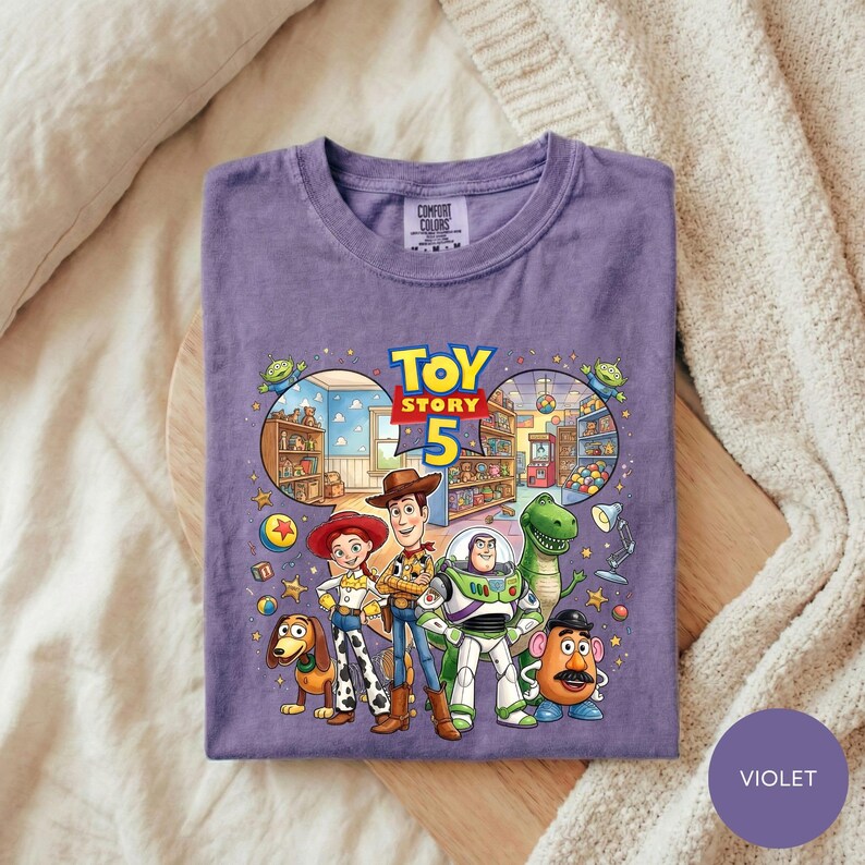 A purple t-shirt with a colorful illustration of characters from the Toy Story movie, including Woody, Buzz Lightyear, and other beloved characters.