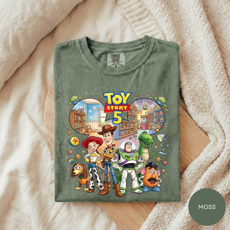 A green t-shirt with a colorful illustration of characters from the Toy Story movie, including Woody, Buzz Lightyear, and other beloved characters.