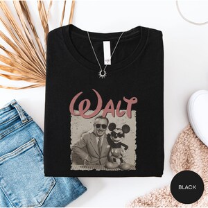 a black t-shirt with a graphic of Mickey Mouse and Walt Disney, along with a necklace and some other clothing items.
