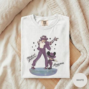 A white t-shirt with a graphic design featuring a man and a child, along with the text "Michael Jackson" and "Mickey Mouse".