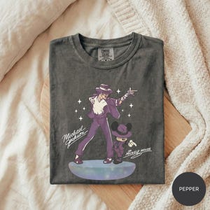 A gray t-shirt with a graphic design featuring a man and a character, likely from a Disney movie, along with the text "Michael Jackson" and "Mickey Mouse".