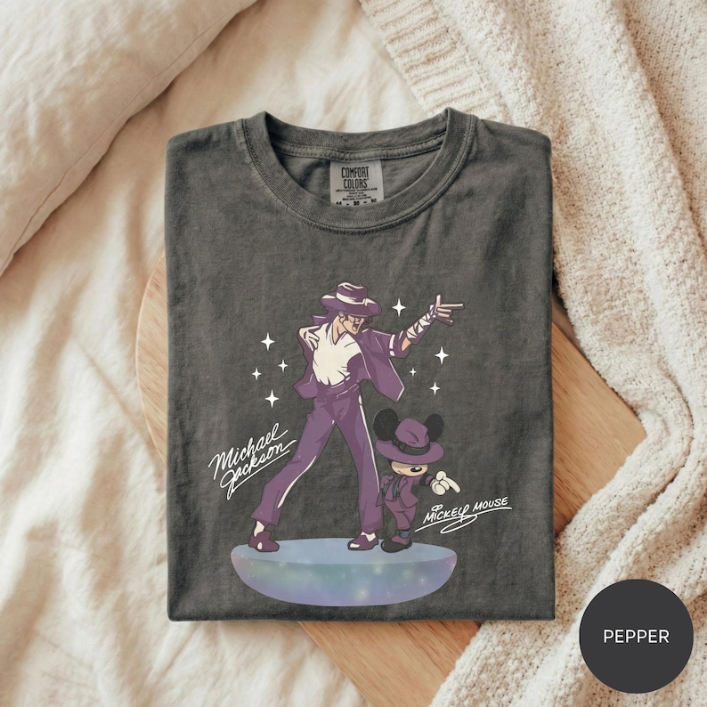 A gray t-shirt with a graphic design featuring a man and a character, likely from a Disney movie, along with the text "Michael Jackson" and "Mickey Mouse".