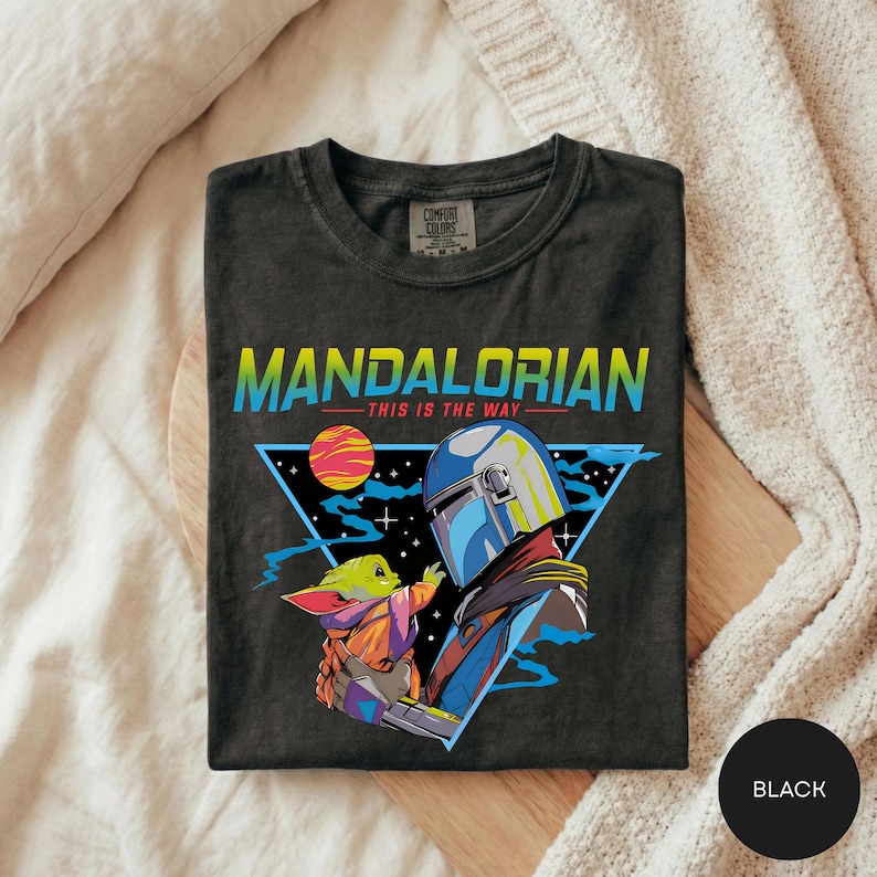 A black t-shirt with a graphic design featuring the characters Yoda and the alien Zorlax from the Star Wars series, along with a space scene.