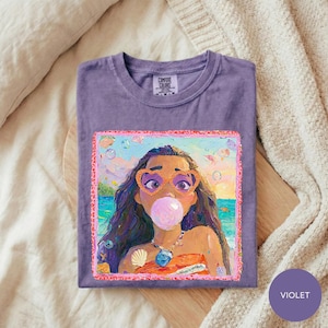 a purple t-shirt with a colorful illustration of a young girl with long hair blowing a bubblegum bubble.