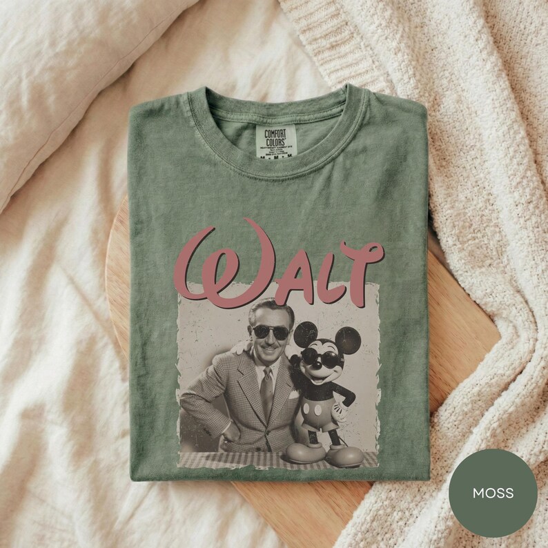 A green t-shirt with a graphic design featuring a man and a character from Disney, specifically Mickey Mouse.