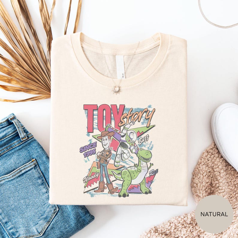 a T-shirt with a colorful graphic of a character from the Toy Story movie, along with a pair of jeans and some other clothing items.