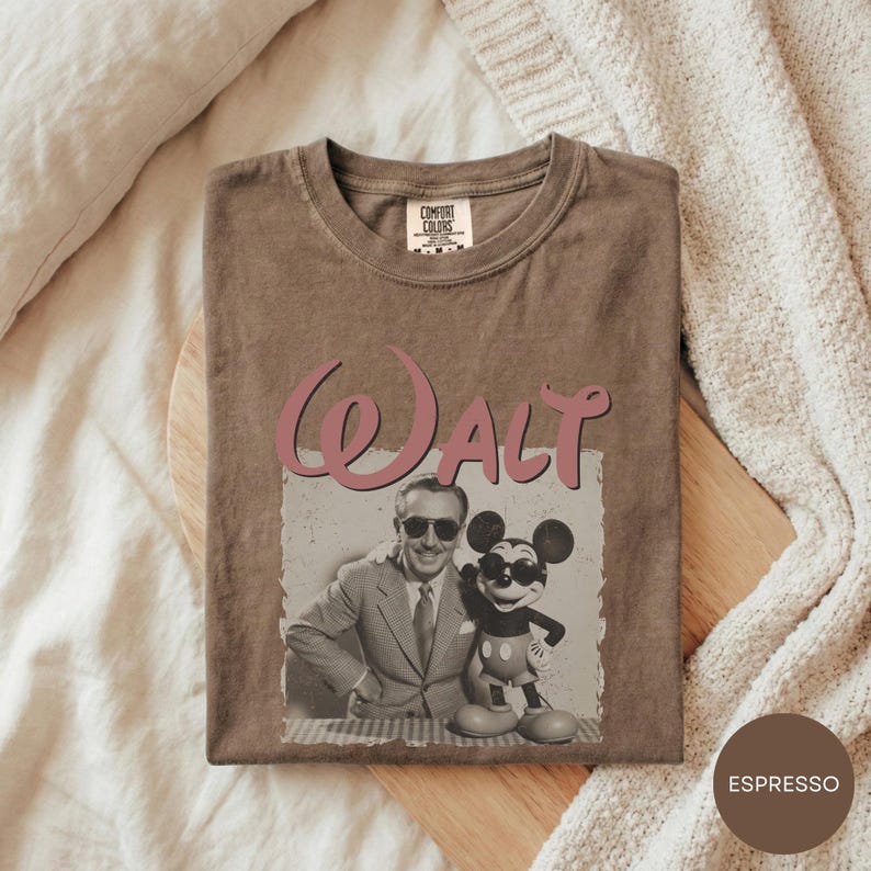 A t-shirt with a graphic design featuring a man and a character from Disney, along with the word "Walt" printed on it.
