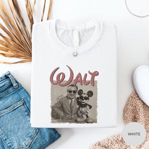 a white t-shirt with a graphic of Mickey Mouse and Walt Disney, along with a small photo of Walt Disney and Mickey Mouse.