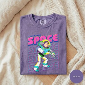 A purple t-shirt with a graphic of a character from the Toy Story franchise, specifically Buzz Lightyear, printed on it.