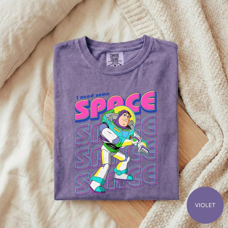 A purple t-shirt with a graphic of a character from the Toy Story franchise, specifically Buzz Lightyear, printed on it.