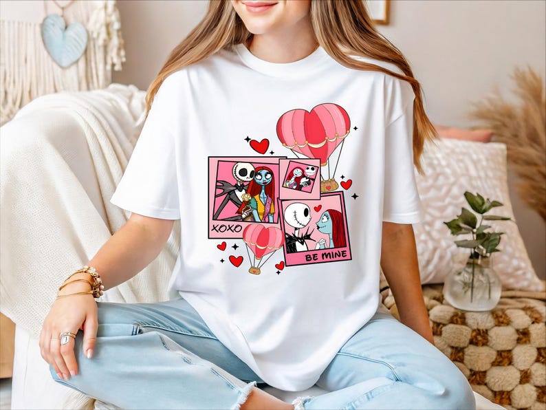 A woman wearing a white t-shirt with a graphic design featuring characters from the movie " Nightmare Before Christmas".