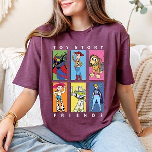 a woman sitting on a couch wearing a toy story t - shirt