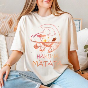 a woman sitting on a couch wearing a t - shirt