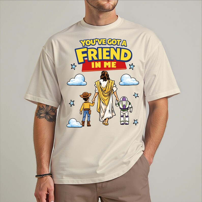 A man wearing a t-shirt with a graphic design featuring a cartoon depiction of Jesus Christ, along with a message that says "You've Got a Friend in Me".