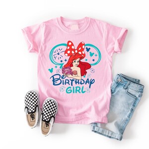 a pink shirt with a cartoon character on it