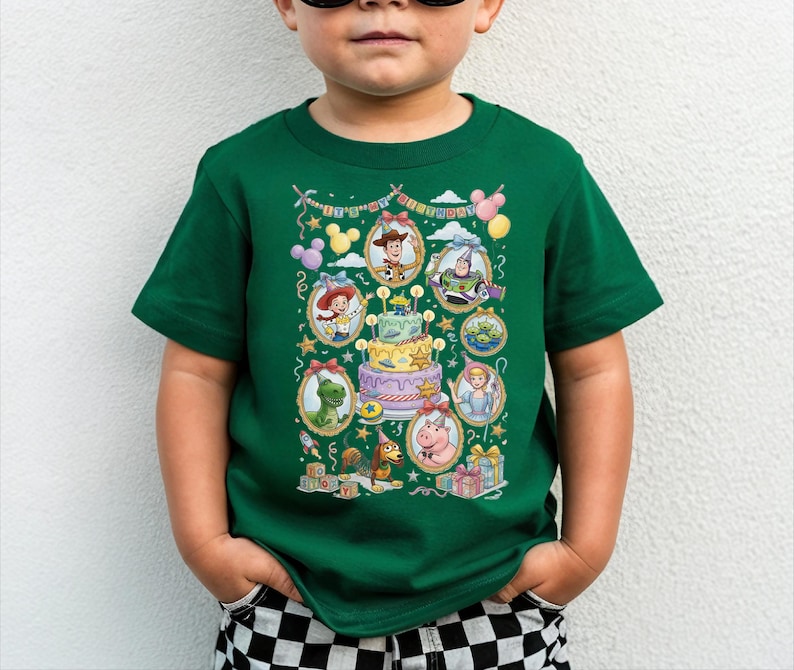 A young boy wearing a green t-shirt with a colorful graphic of characters from the Toy Story movie.