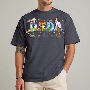 A man wearing a gray t-shirt with a colorful graphic design featuring characters from the Toy Story franchise.