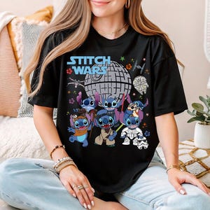 a woman sitting on a bed wearing a black stitch wars t - shirt
