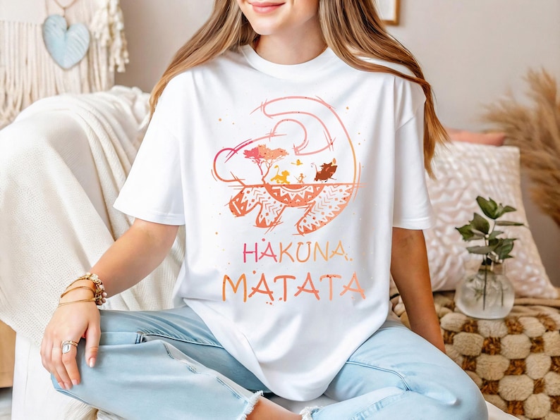 a woman sitting on a couch wearing a t - shirt that says hakona
