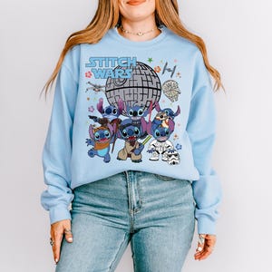 a woman wearing a blue sweatshirt with cartoon characters on it