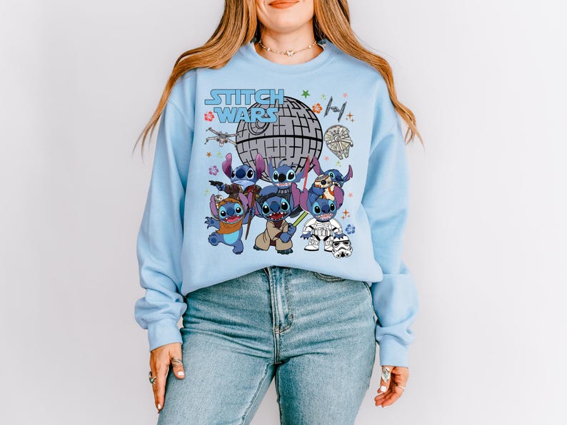 a woman wearing a blue sweatshirt with cartoon characters on it