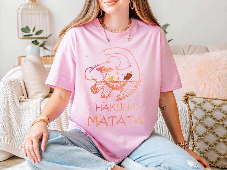 a woman sitting on a couch wearing a pink shirt