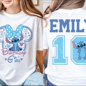 May include: White t-shirt featuring a blue cartoon character with a large bow and the text "Birthday Girl". The back of the shirt displays the name "EMILY" above the number "10" and the same cartoon character.