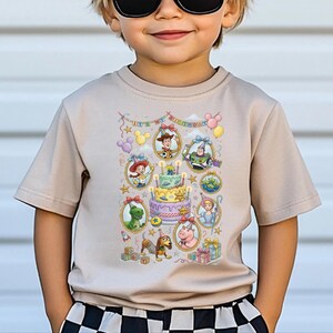A young boy wearing a t-shirt with a colorful graphic of characters from the Toy Story movie, including Woody, Buzz Lightyear, and other beloved characters.