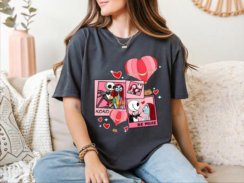 A woman wearing a black t-shirt with a graphic design featuring characters from the movie " Nightmare Before Christmas".