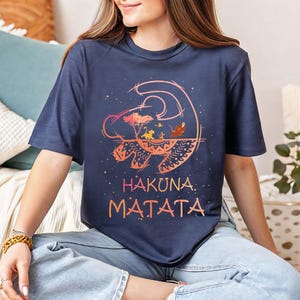 a woman sitting on a bed wearing a t - shirt that says hakkana