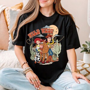 a woman sitting on a bed wearing a black shirt