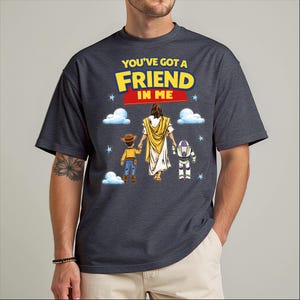 A man wearing a black t-shirt with a graphic design featuring a character from the Toy Story franchise, along with the text "You've got a friend in me" and a Bible verse.