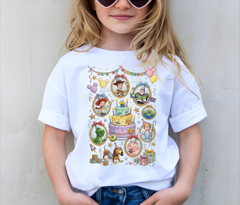 A young girl wearing a white t-shirt with a colorful graphic design featuring characters from the Toy Story movie.