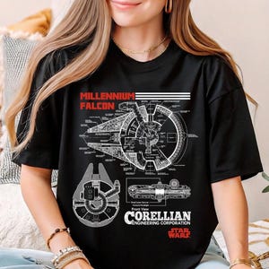 May include: Black t-shirt featuring a detailed schematic of the Millennium Falcon, with the text "MILLENNIUM FALCON" in red and white. The design includes the Corellian Engineering Corporation logo and "STAR WARS" text.