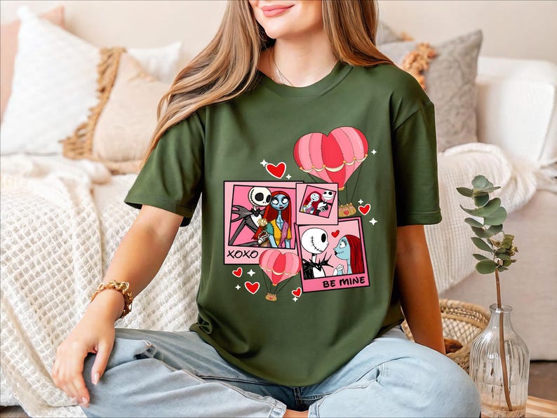 A woman wearing a green t-shirt with a graphic design featuring characters from the movie " Nightmare Before Christmas".