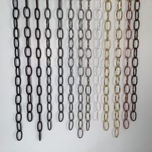 May include: A collection of decorative chains in various colors, including black, bronze, silver, white, gold, and copper. The chains are made of metal and have an oval link design. These chains are suitable for lighting fixtures and other decorative purposes.