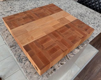 May include: A large, rectangular wooden cutting board with a checkered pattern. The board is made of two different types of wood, one light and one dark. The board is sitting on a granite countertop.