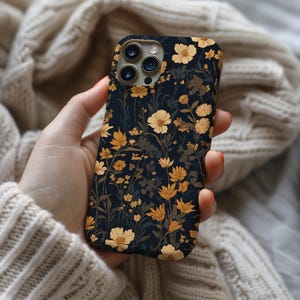 May include: A black phone case with a floral pattern. The flowers are yellow and white and are on a dark blue background.