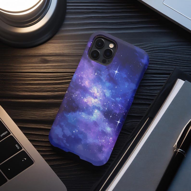 May include: A purple and blue galaxy phone case with a watercolor effect and white stars. The case has a cutout for the camera lens.