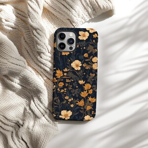 May include: A black phone case with a floral pattern featuring yellow and white flowers on a dark blue background.