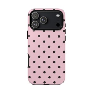 May include: A pink phone case with a black polka dot pattern. The case has a camera cutout for a triple-lens camera system. The case is designed to fit a smartphone.