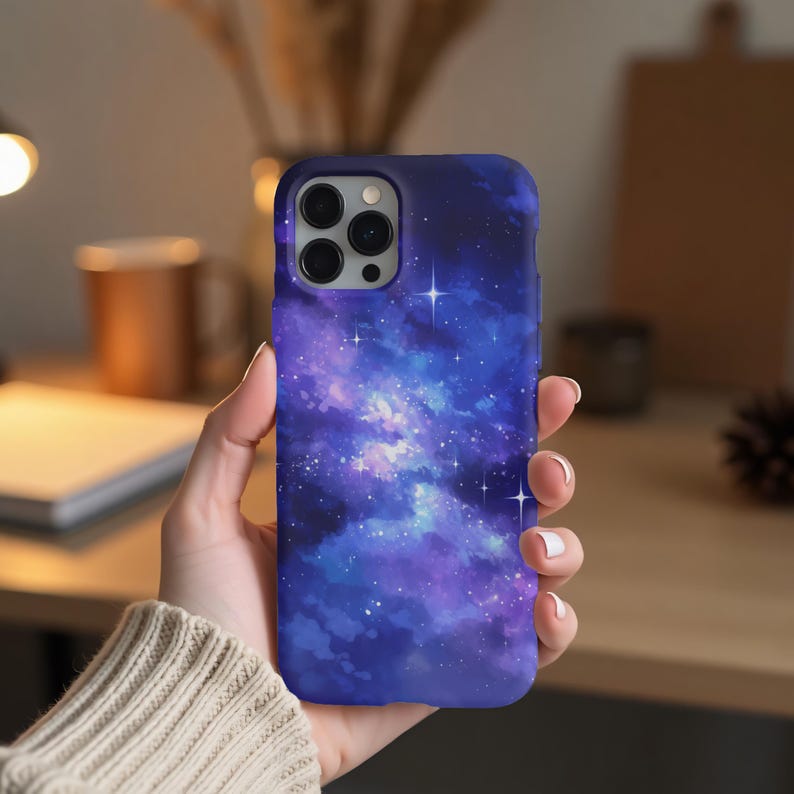 May include: A blue and purple galaxy phone case with white stars. The case has a camera cutout and is made of a soft, flexible material.