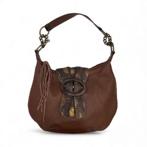 May include: Brown leather hobo bag with a decorative flap and oval buckle. The bag features a shoulder strap with metal chain accents and a tassel detail. The flap has a snakeskin pattern with gold and brown tones.